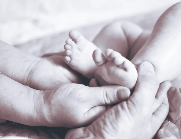 little feet in father\'s hands