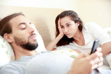 Pareja adicta al mvil en la cama