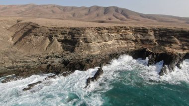 Okyanusun gücü dağların yanındaki kayalıklara çarpar.