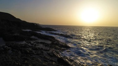 Okyanusun gücü dağların yanındaki kayalıklara çarpar.