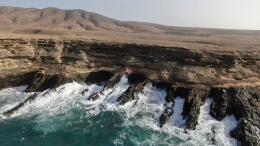 Okyanusun gücü dağların yanındaki kayalıklara çarpar.