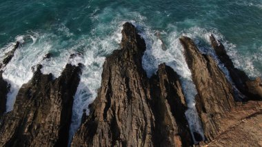 Okyanusun gücü dağların yanındaki kayalıklara çarpar.