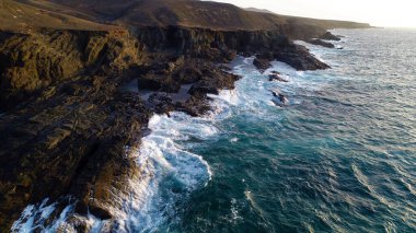 Okyanusun gücü dağların yanındaki kayalıklara çarpar.