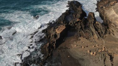 Okyanusun gücü dağların yanındaki kayalıklara çarpar.