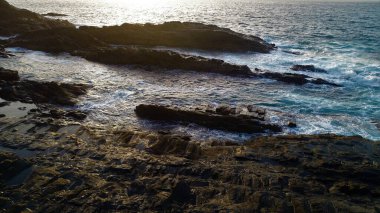 Okyanusun gücü dağların yanındaki kayalıklara çarpar.