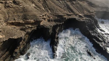 Okyanusun gücü dağların yanındaki kayalıklara çarpar.