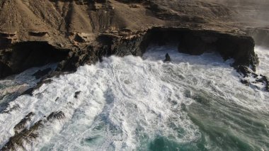 Okyanusun gücü dağların yanındaki kayalıklara çarpar.