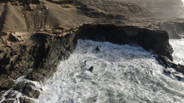 Okyanusun gücü dağların yanındaki kayalıklara çarpar.