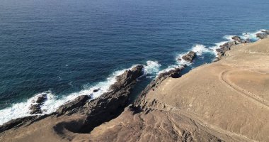 Okyanusun gücü dağların yanındaki kayalıklara çarpar.