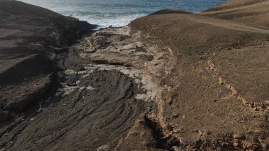 Okyanusun gücü dağların yanındaki kayalıklara çarpar.