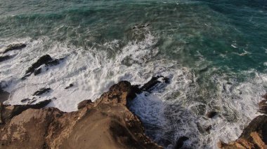 Okyanusun gücü dağların yanındaki kayalıklara çarpar.