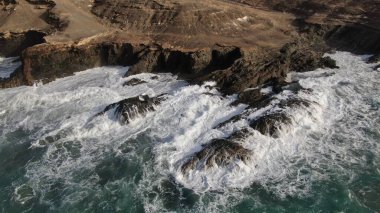 Okyanusun gücü dağların yanındaki kayalıklara çarpar.