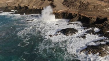 Okyanusun gücü dağların yanındaki kayalıklara çarpar.