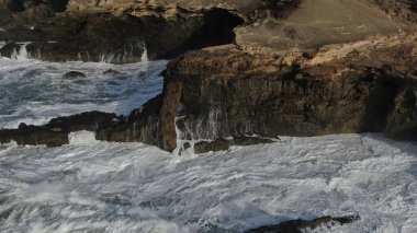 Okyanusun gücü dağların yanındaki kayalıklara çarpar.