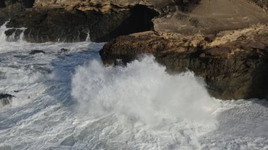 Okyanusun gücü dağların yanındaki kayalıklara çarpar.