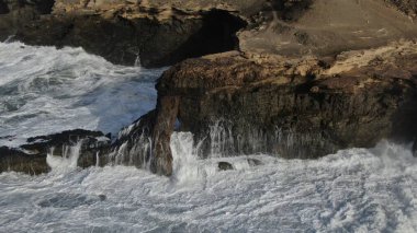 Okyanusun gücü dağların yanındaki kayalıklara çarpar.