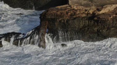 Okyanusun gücü dağların yanındaki kayalıklara çarpar.