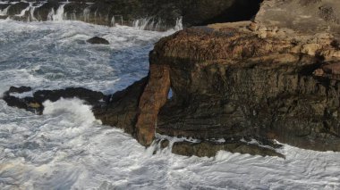 Okyanusun gücü dağların yanındaki kayalıklara çarpar.