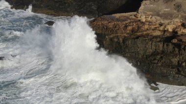 Okyanusun gücü dağların yanındaki kayalıklara çarpar.