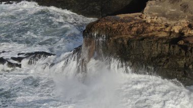 Okyanusun gücü dağların yanındaki kayalıklara çarpar.