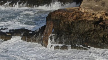 Okyanusun gücü dağların yanındaki kayalıklara çarpar.