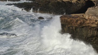 Okyanusun gücü dağların yanındaki kayalıklara çarpar.