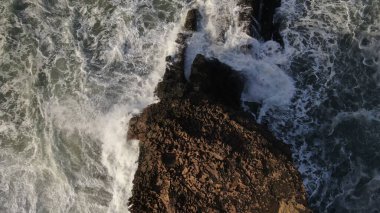 Okyanusun gücü dağların yanındaki kayalıklara çarpar.