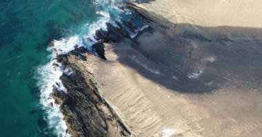 Okyanusun gücü dağların yanındaki kayalıklara çarpar.