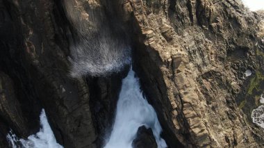 Okyanusun gücü dağların yanındaki kayalıklara çarpar.