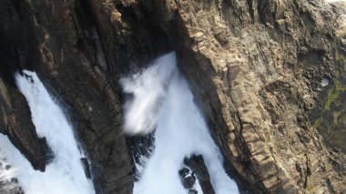 Okyanusun gücü dağların yanındaki kayalıklara çarpar.