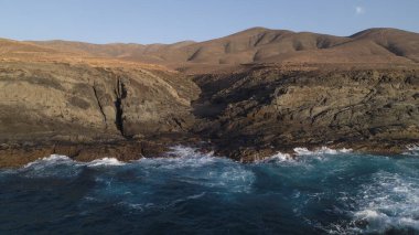 Okyanusun gücü dağların yanındaki kayalıklara çarpar.