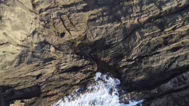 Okyanusun gücü dağların yanındaki kayalıklara çarpar.