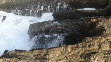Okyanusun gücü dağların yanındaki kayalıklara çarpar.