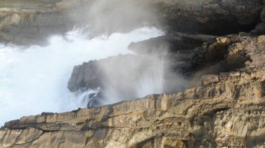 Okyanusun gücü dağların yanındaki kayalıklara çarpar.