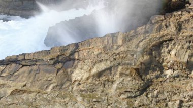 Okyanusun gücü dağların yanındaki kayalıklara çarpar.