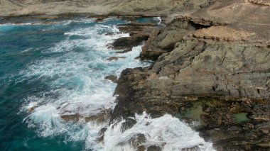 Okyanusun gücü dağların yanındaki kayalıklara çarpar.