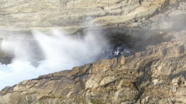 Okyanusun gücü dağların yanındaki kayalıklara çarpar.