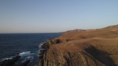 Okyanusun gücü dağların yanındaki kayalıklara çarpar.