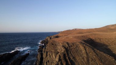 Kayalıklardan gün batımı denizin, dağların, ufkun ve Atlantik Okyanusunun gücünü düşünüyordu.