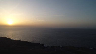 Kayalıklardan gün batımı denizin, dağların, ufkun ve Atlantik Okyanusunun gücünü düşünüyordu.