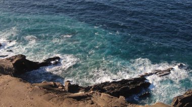 Kayalıklardan gün batımı denizin, dağların, ufkun ve Atlantik Okyanusunun gücünü düşünüyordu.
