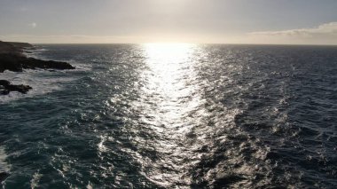 Kayalıklardan gün batımı denizin, dağların, ufkun ve Atlantik Okyanusunun gücünü düşünüyordu.