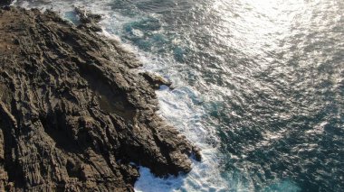 Kayalıklardan gün batımı denizin, dağların, ufkun ve Atlantik Okyanusunun gücünü düşünüyordu.