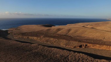 Kayalıklardan gün batımı denizin, dağların, ufkun ve Atlantik Okyanusunun gücünü düşünüyordu.