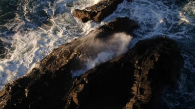 Kayalıklardan gün batımı denizin, dağların, ufkun ve Atlantik Okyanusunun gücünü düşünüyordu.