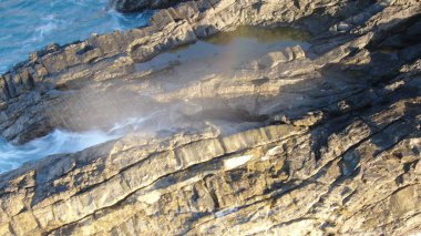 Kayalıklardan gün batımı denizin, dağların, ufkun ve Atlantik Okyanusunun gücünü düşünüyordu.