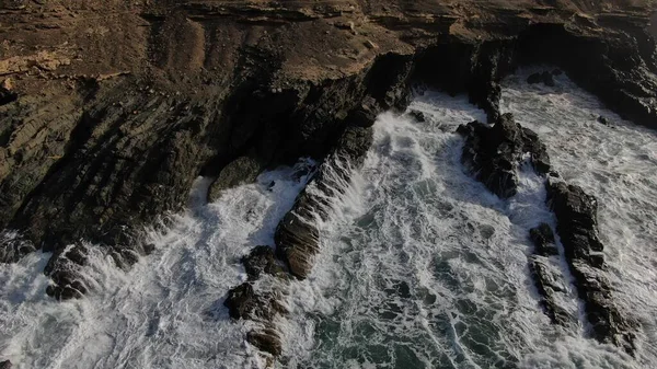 Okyanusun gücü dağların yanındaki kayalıklara çarpar.