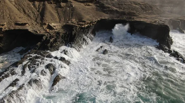 Okyanusun gücü dağların yanındaki kayalıklara çarpar.