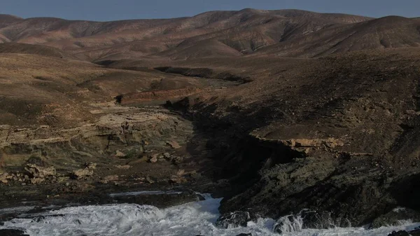 Okyanusun gücü dağların yanındaki kayalıklara çarpar.