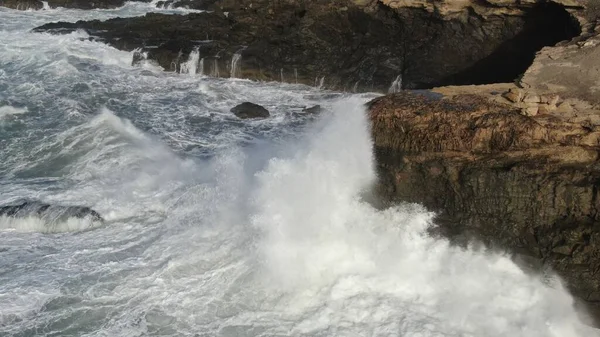 Okyanusun gücü dağların yanındaki kayalıklara çarpar.